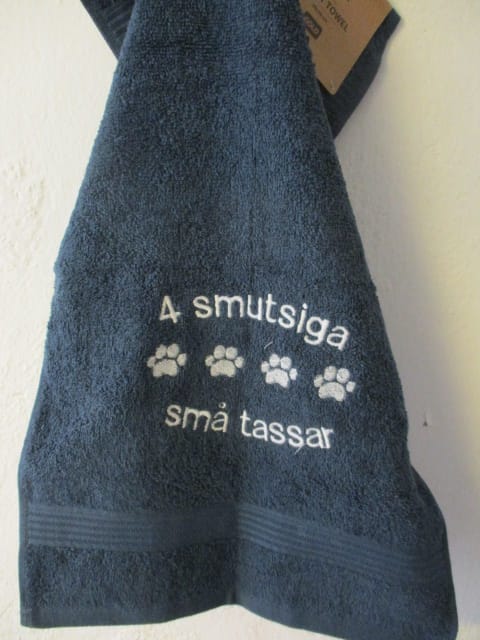 Frottehandduk med maskinbroderat motiv, "4 smutsiga små tassar". 30 x 50 cm. Mörkblå.