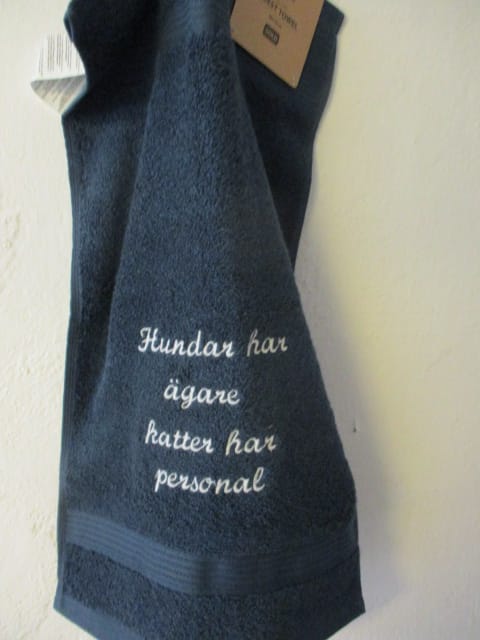Frottehandduk med maskinbroderat motiv, "Hundar har ägare, katter har personal". 30 x 50 cm. Mörkblå.