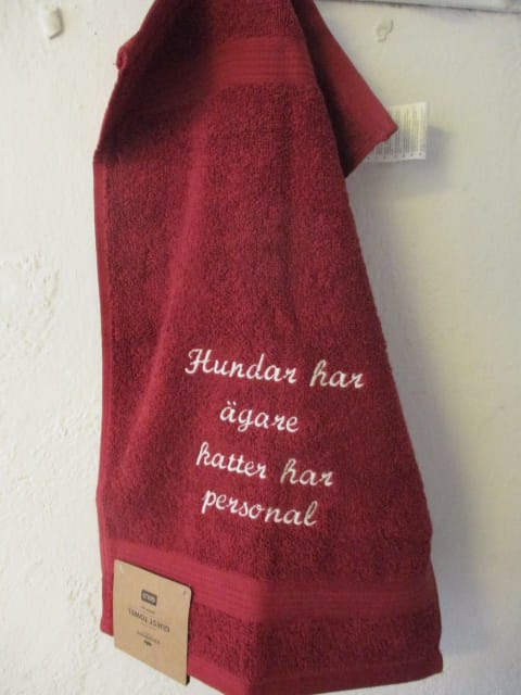 Frottehandduk med maskinbroderat motiv, "Hundar har ägare, katter har personal". 30 x 50 cm. Vinröd