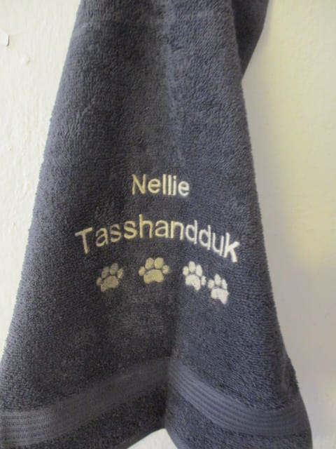 Din hunds namn på tasshandduk. Grå frottehandduk med maskinbroderat motiv 30 x 50 cm.