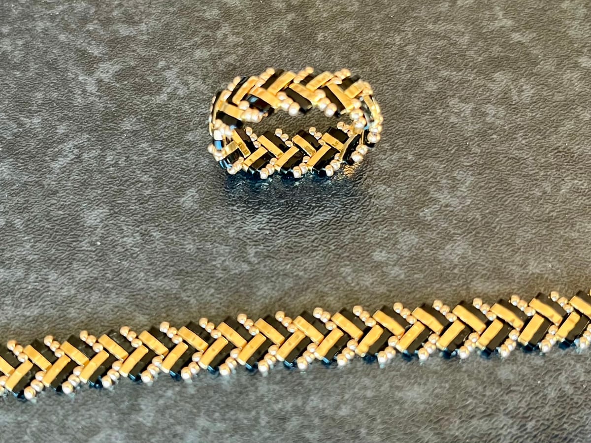 Set av armband och ring i svart och guld