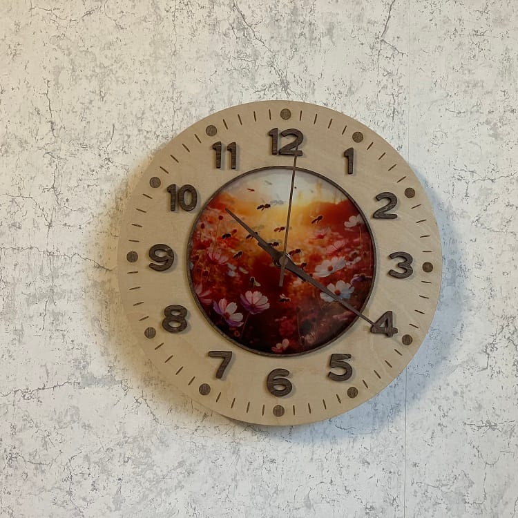 Dekorativ väggklocka med blom- och bimotiv