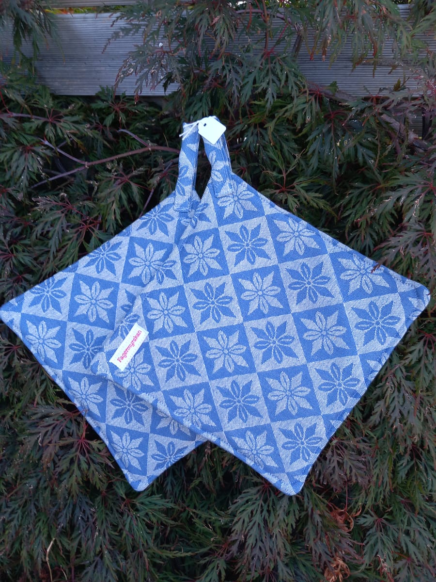 Klassiska grytlappar av blått bolstertyg.