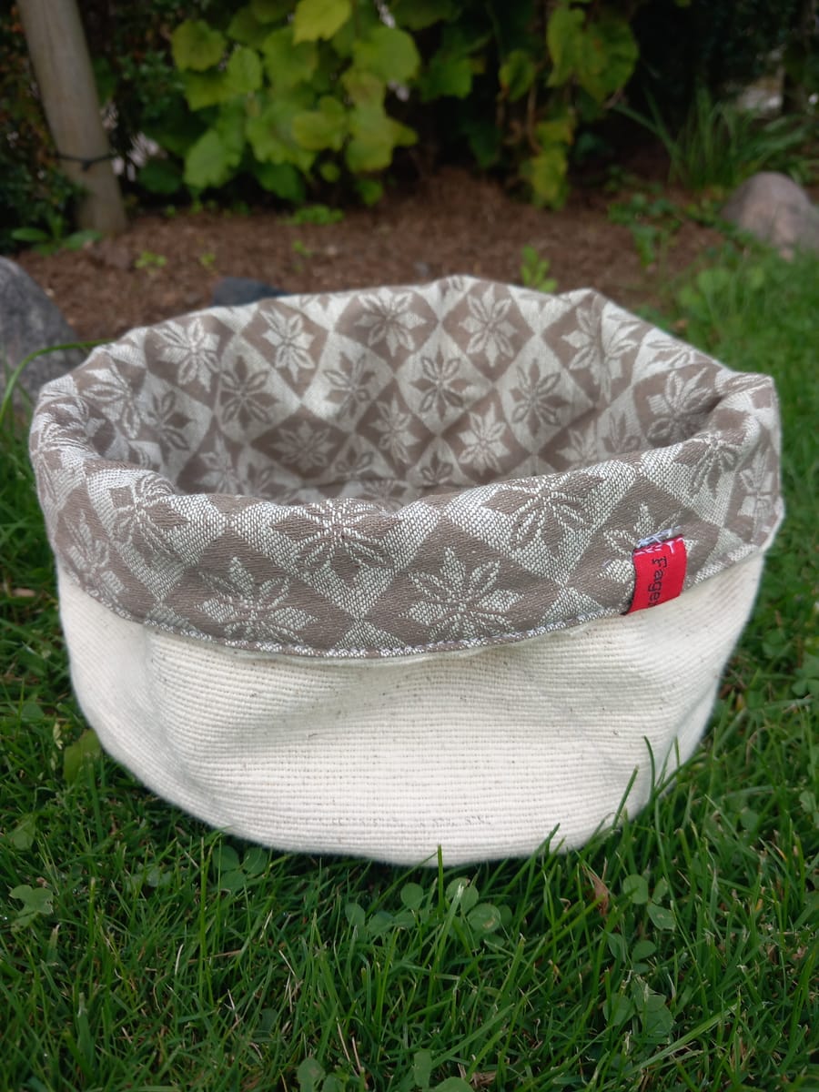 Fin brödkorg i beige bolstertyg och vit utsida.