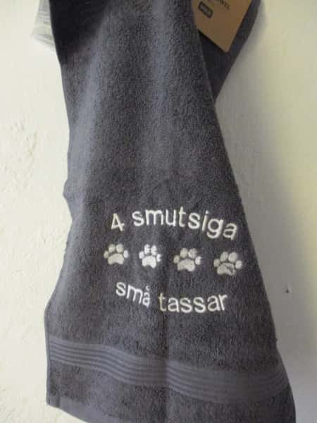 Frottehandduk med maskinbroderat motiv, "4 smutsiga små tassar". 30 x 50 cm. Grå.