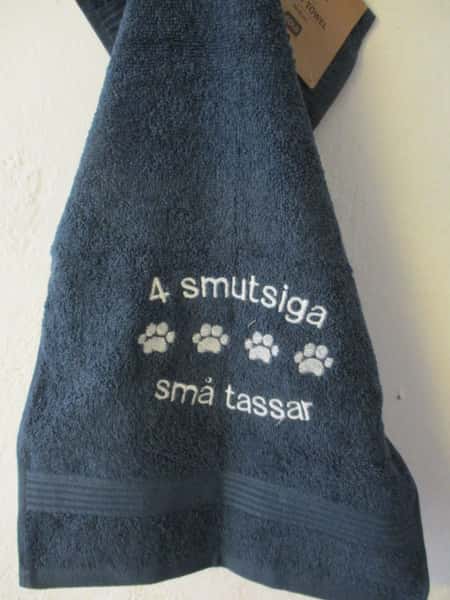 Frottehandduk med maskinbroderat motiv, "4 smutsiga små tassar". 30 x 50 cm. Mörkblå.