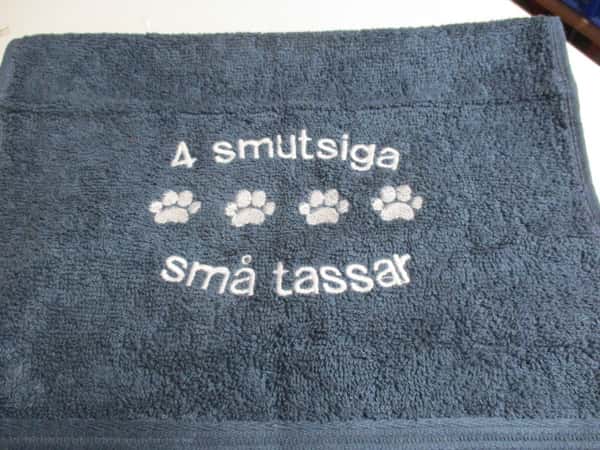 Frottehandduk med maskinbroderat motiv, "4 smutsiga små tassar". 30 x 50 cm. Mörkblå.