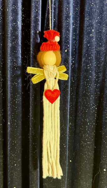 Handgjord julängel i flätat snöre med rött hjärta – brun hår i knut med röd mössa och vit tofs