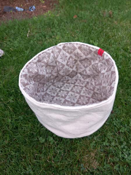 Fin brödkorg i beige bolstertyg och vit utsida.